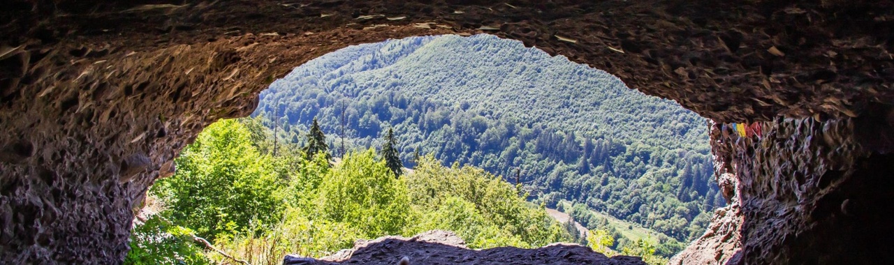 kilátás egy barlangból a napos tájra